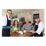 Students help out staff at a community school cafe