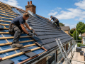 Professional roofers carrying out roofing work on a residential property as part of Roofing Contractors in Eastbourne.