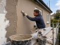 Professional Rendering Services in Eastbourne applying a smooth render finish to an exterior wall.