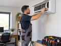 Air Conditioning Services in Eastbourne with an engineer servicing a wall-mounted unit